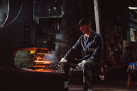 Person beim schmieden einer Pfanne