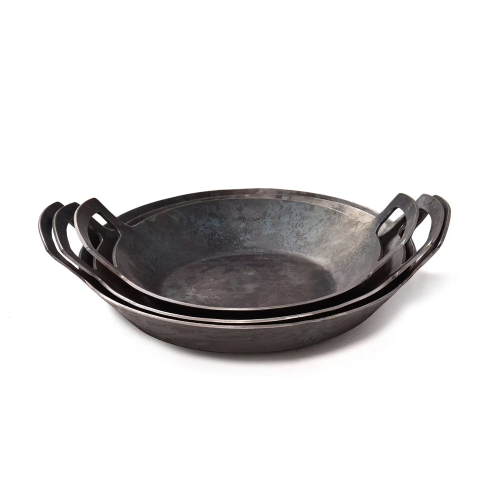 Drei Geschmiedete Servierpfannen, hoher Rand von Albert Turk GmbH & Co. KG, in verschiedenen Größen mit je zwei Henkeln, sind auf weißem Grund ineinander verschachtelt.