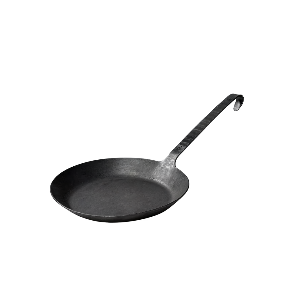 Die Geschmiedete Bratpfanne von Albert Turk GmbH & Co. KG aus schwarzem Gusseisen mit langem, gebogenem Griff und Haken steht für traditionelle Schmiedekunst - elegant vor weißem Hintergrund präsentiert.